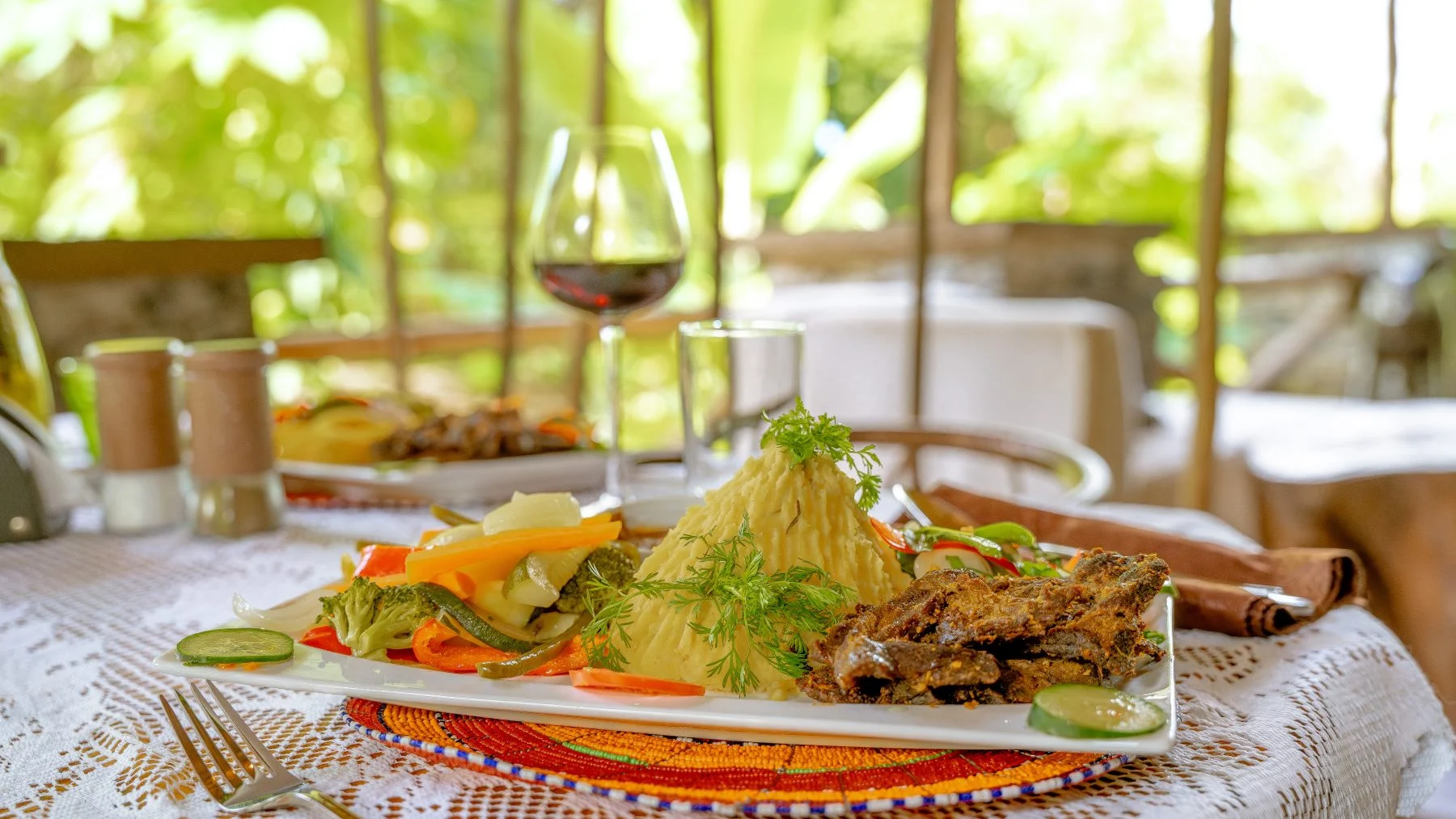 A table laid for dinner in the garden at Sio Maasai, Usa River
