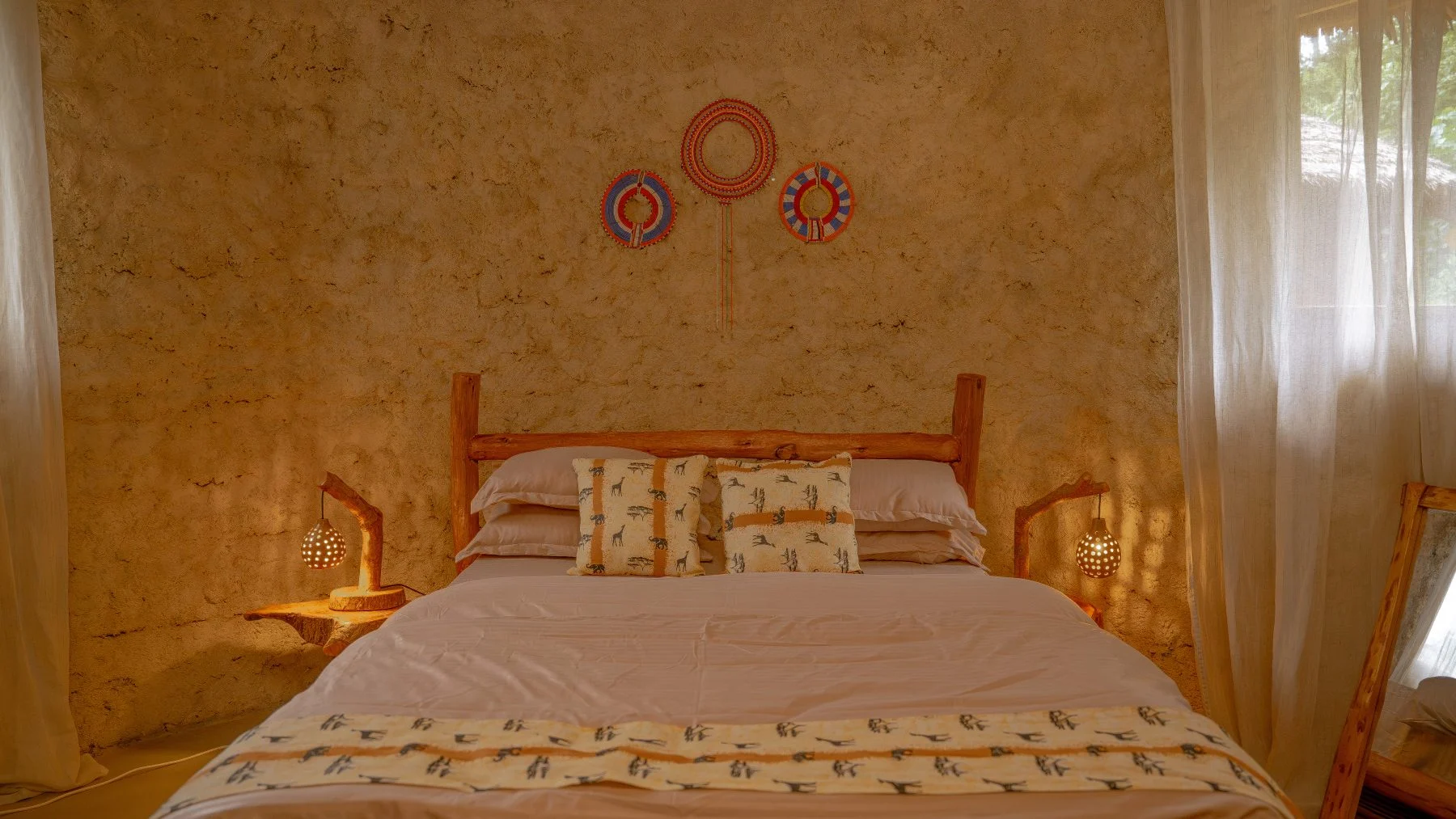 A Standard Double Room at Sio Maasai, with a double bed under a thatched roof